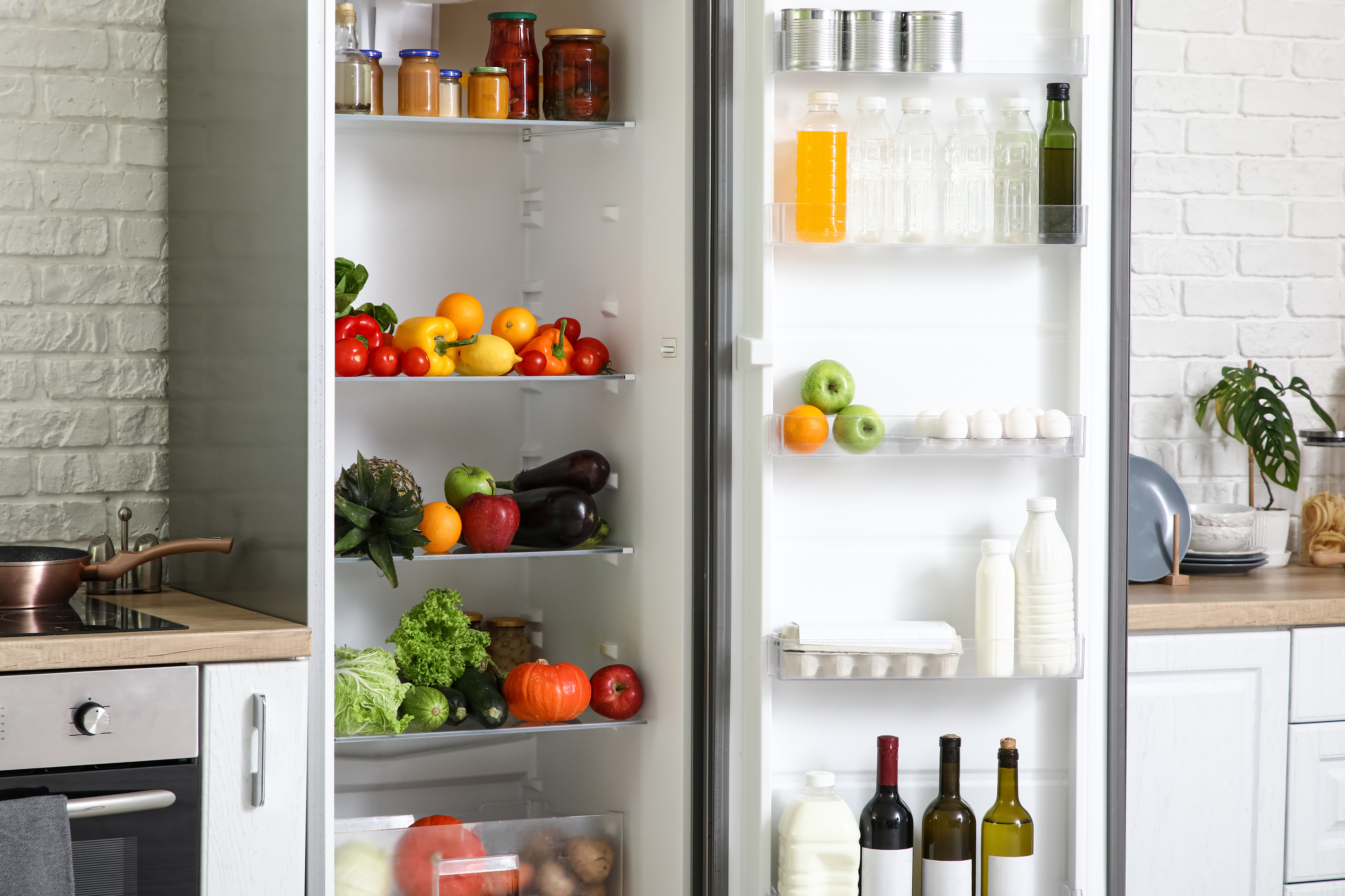 Organised refrigerator storing fresh food safely on separate shelves in a home kitchen